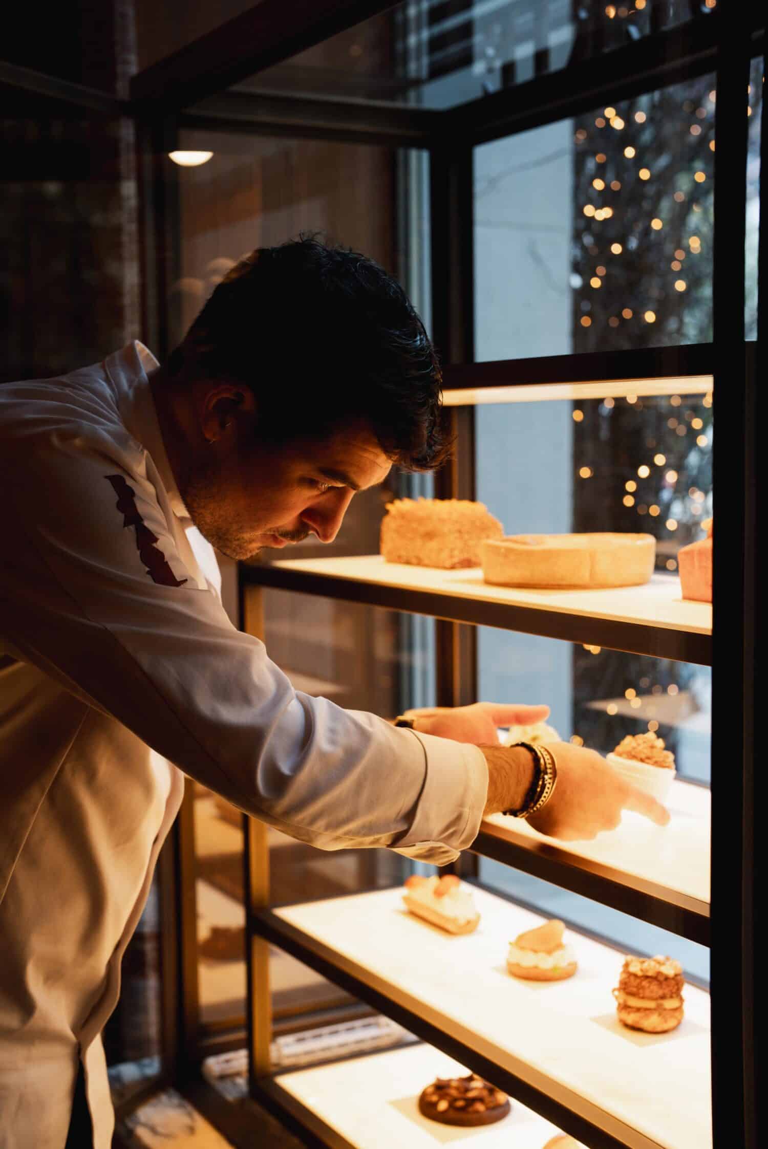 Chef pâtissier disposant des créations sucrées dans la vitrine du Brach Madrid.