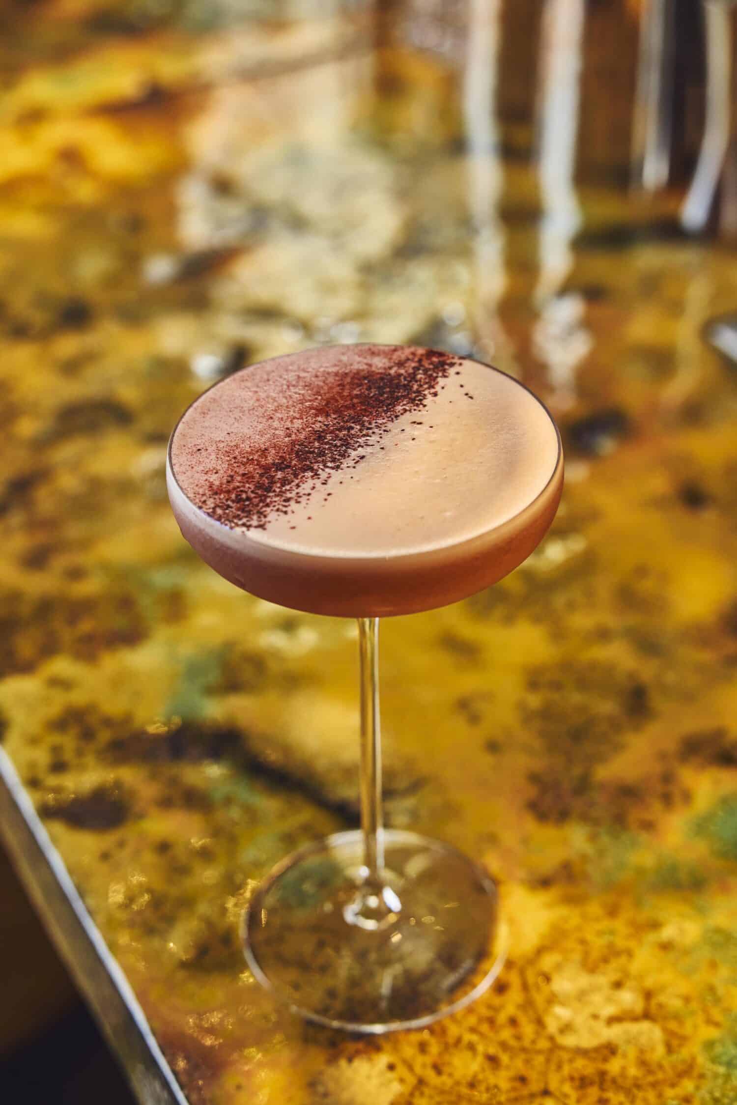 Cocktail raffiné servi au bar du Brach Madrid sur un comptoir en marbre.