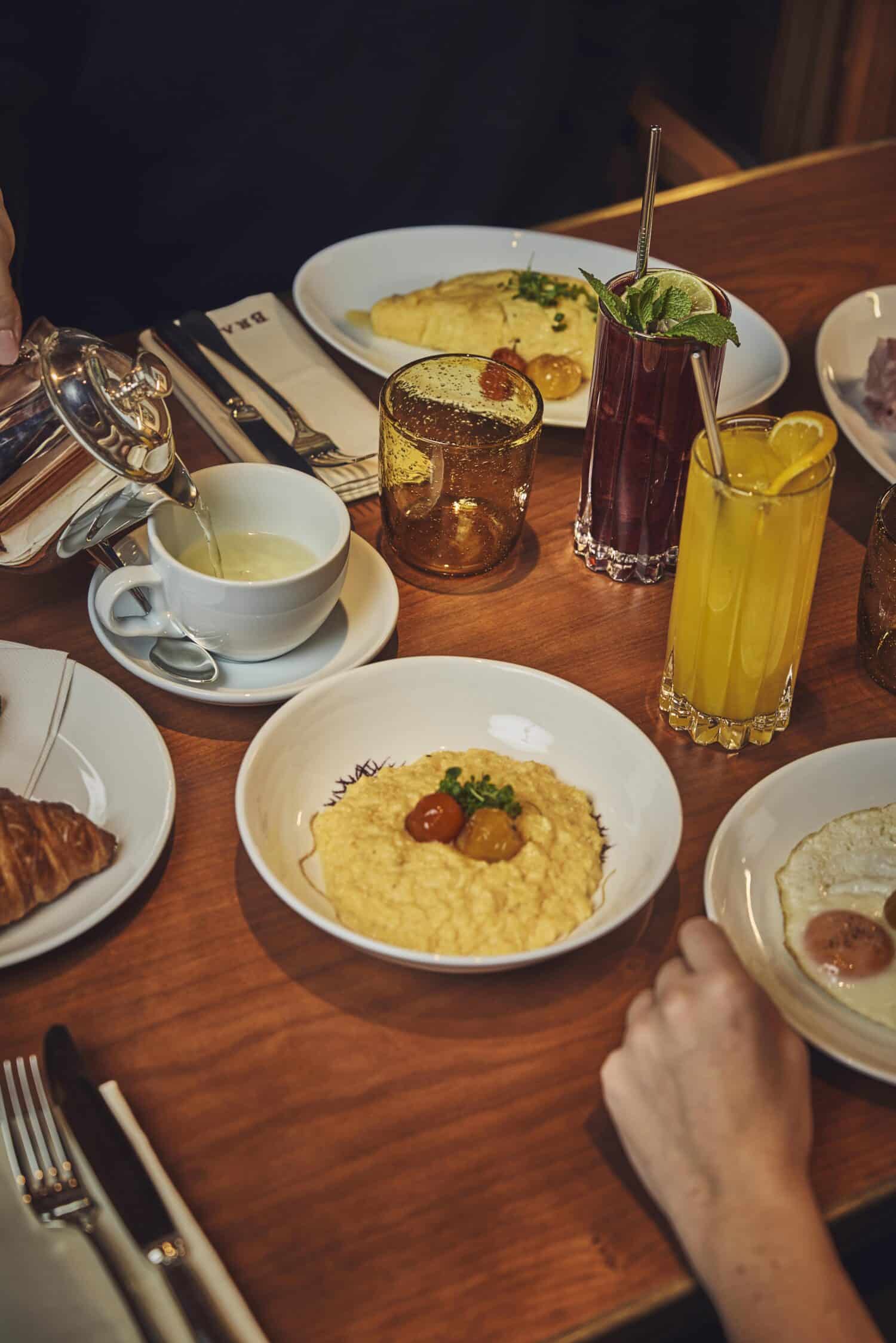 Petit-déjeuner au Brach Madrid avec œufs brouillés, viennoiseries et jus frais.