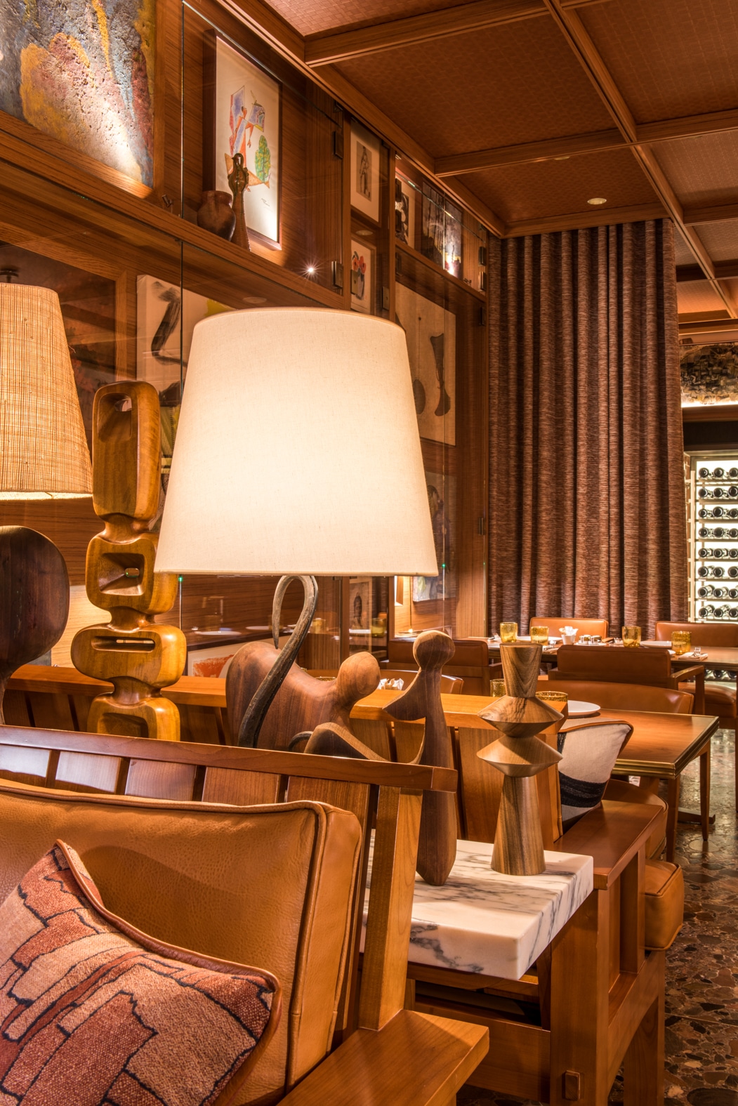 Intérieur du Brach Madrid Restaurant avec banquettes en cuir, éclairage tamisé et murs décorés d’œuvres d’art.