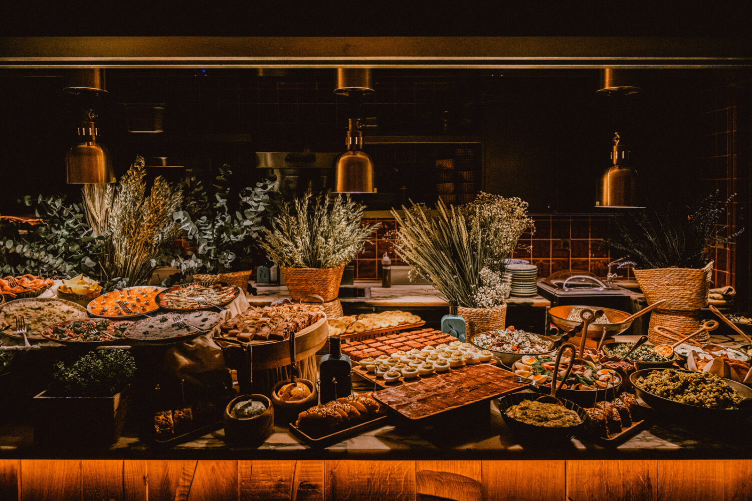 Buffet gourmand du brunch au Brach Madrid Restaurant avec une variété de plats et un décor végétal.